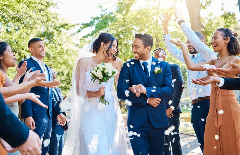 Guests throwing rose petals over the couple