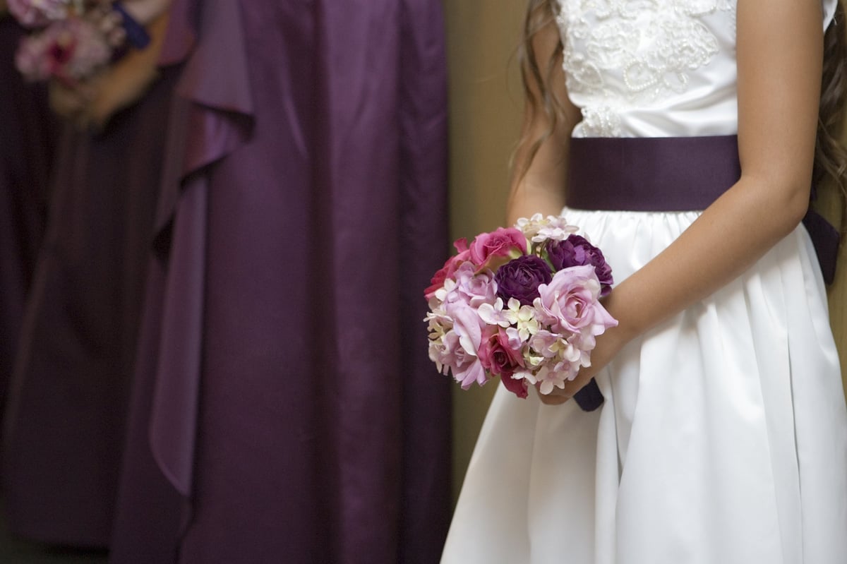 A flower girls wait for the wedding ceremony to start.