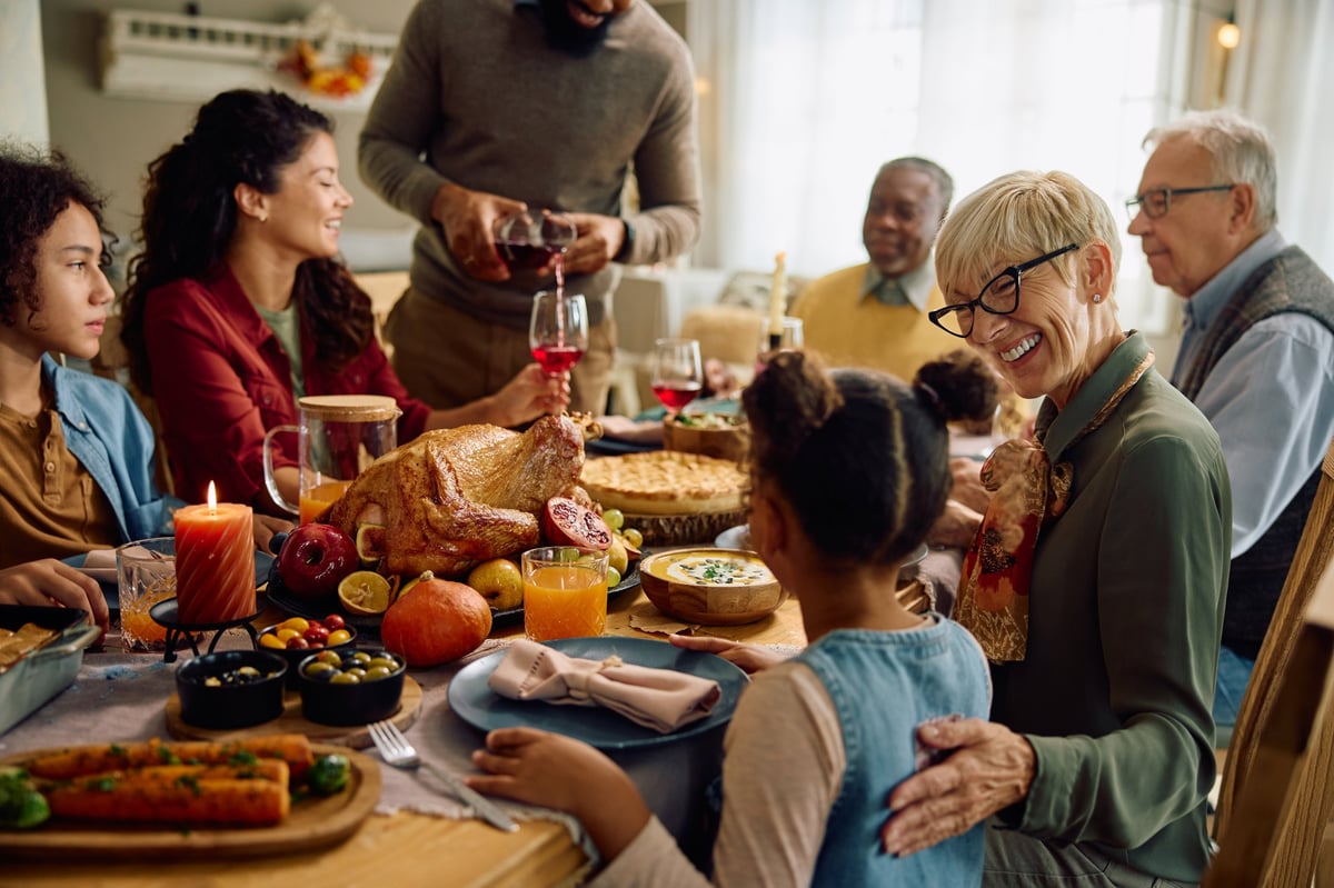 Happy multiracial extended family having Thanksgiving meal at dining table