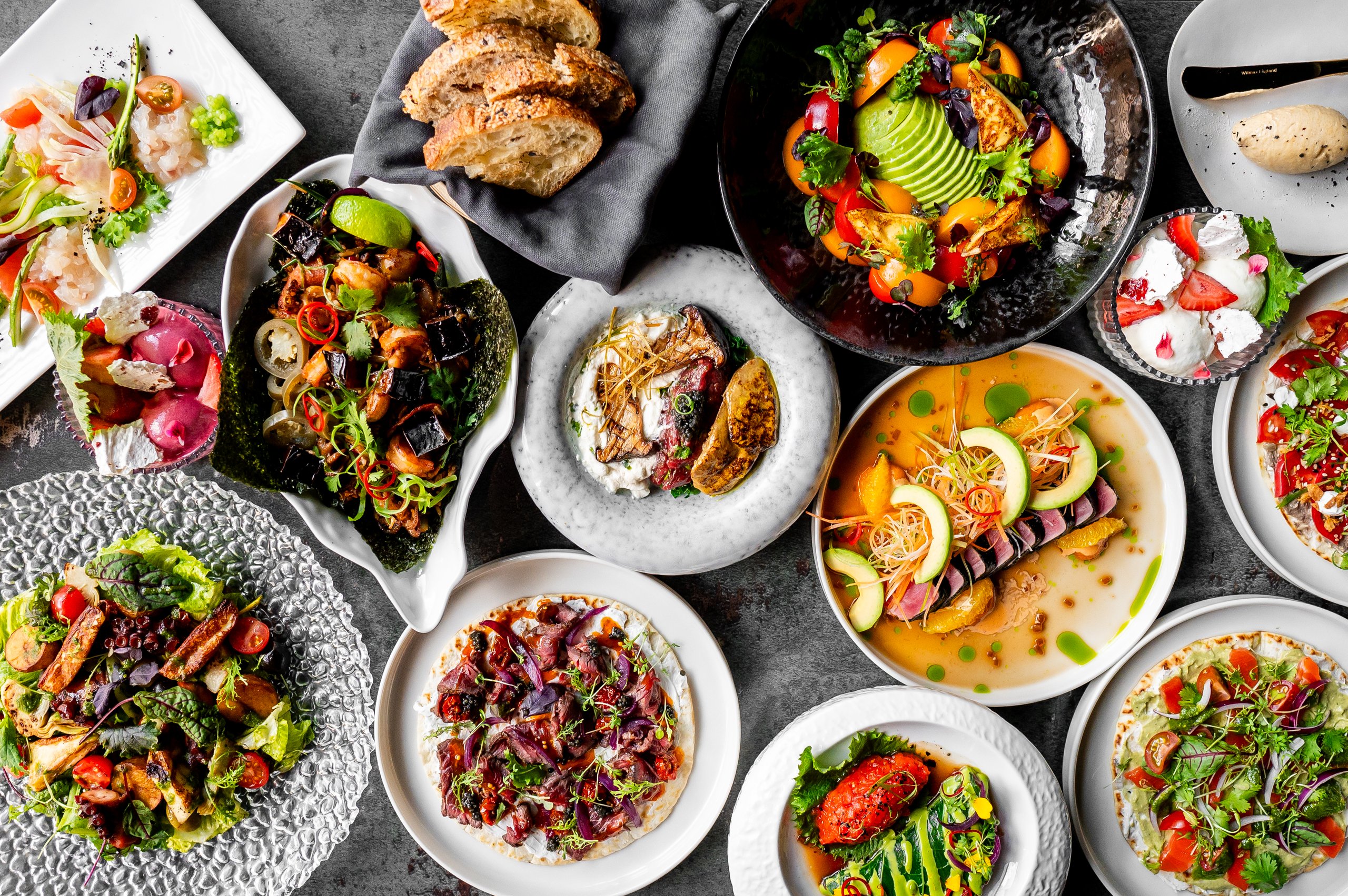 Variety of gourmet dishes displayed on a table, showcasing an array of colors and textures