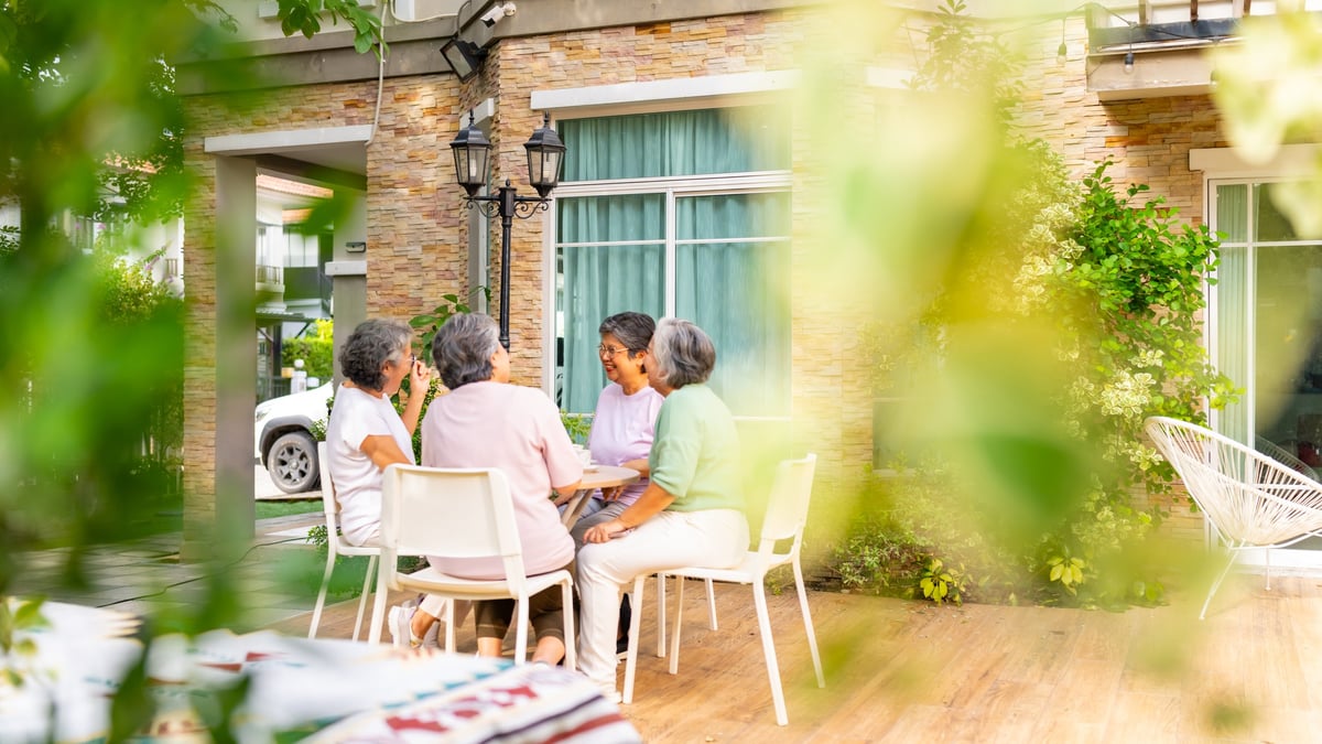 Group of happy senior mature women enjoying indoor lifestyle meeting party together at home