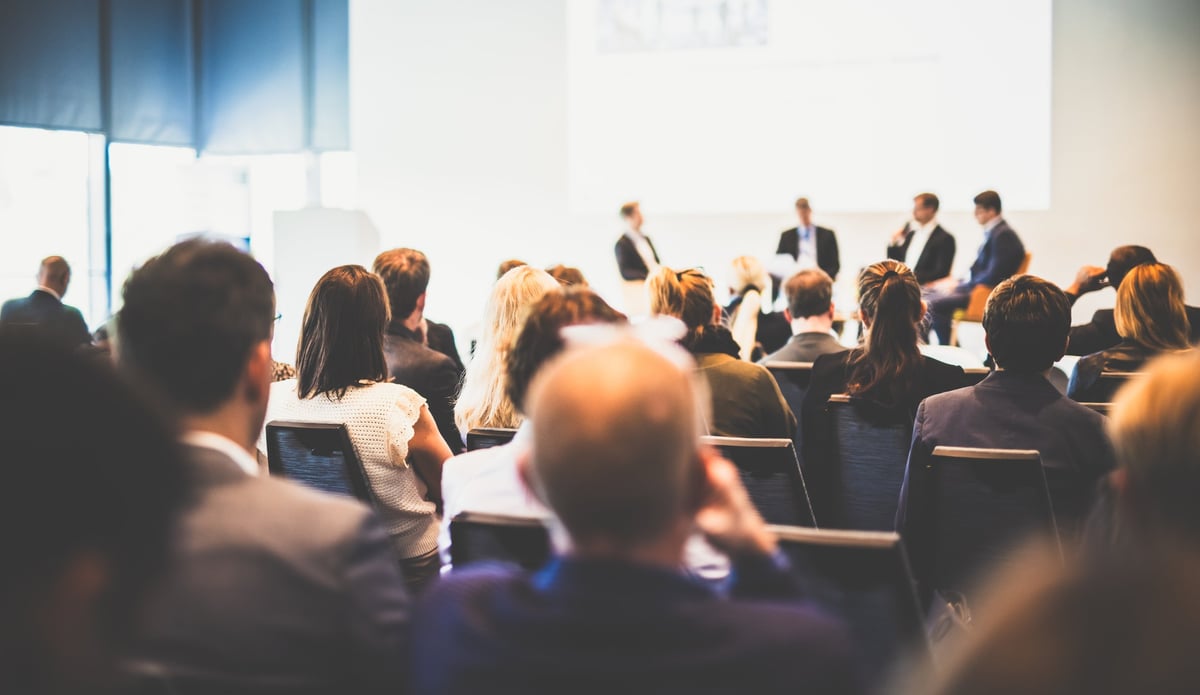 Round table discussion at a business convention with audience in the conference hall