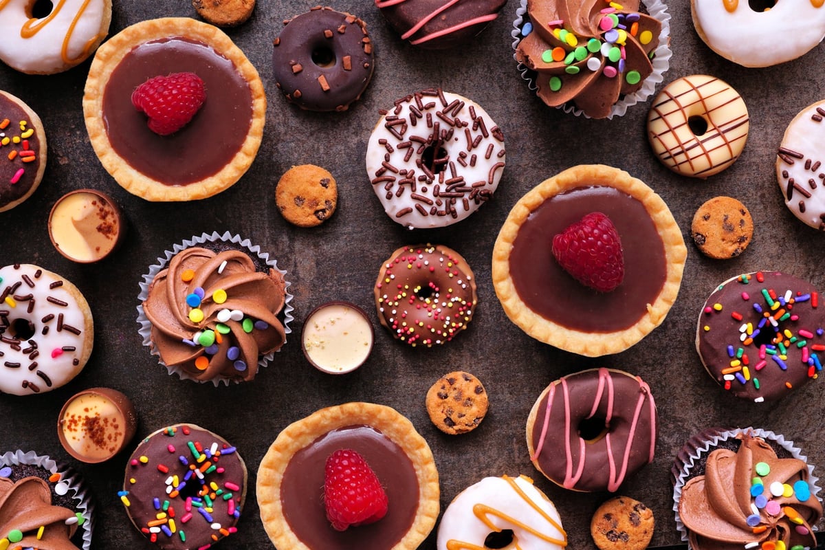 Dessert background with a selection of sweets on a dark stone background
