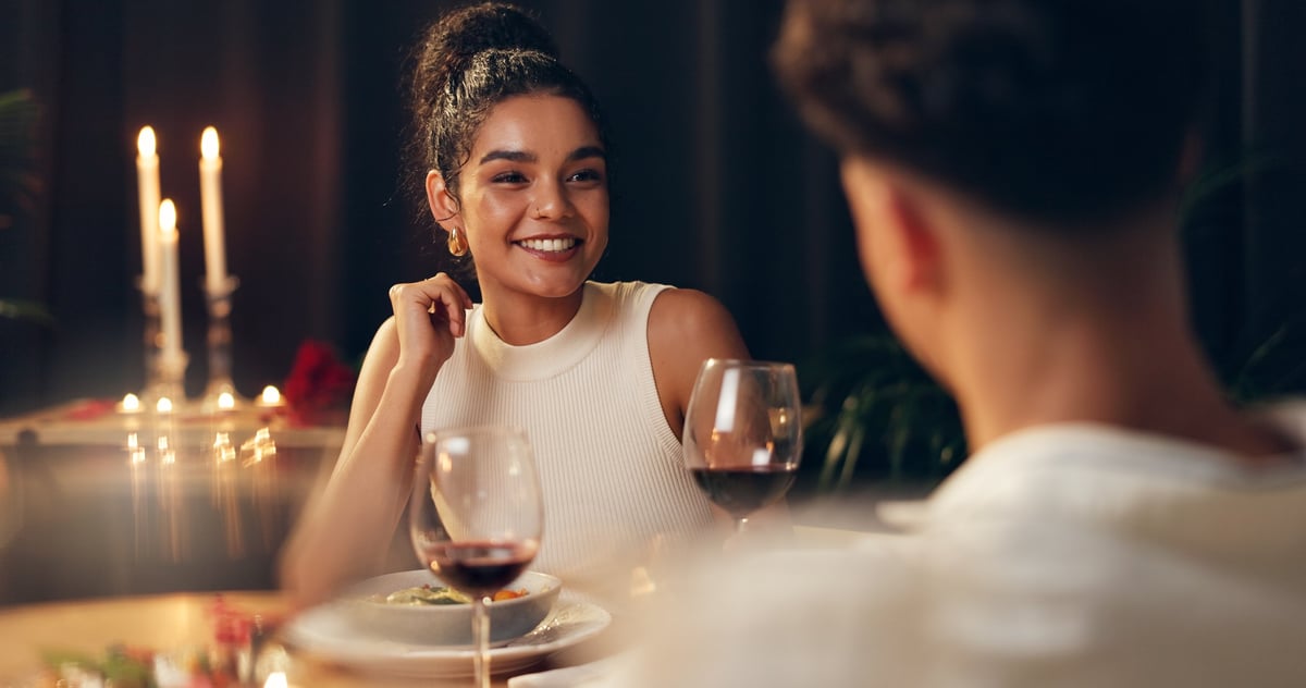 Couple on romantic dinner date at restaurant on Valentine's Day with red wine celebrating anniversary