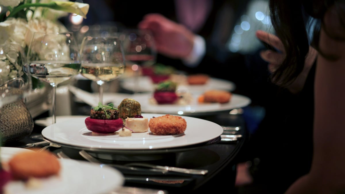 A beautifully plated gourmet dish served at a sophisticated event with fine wine