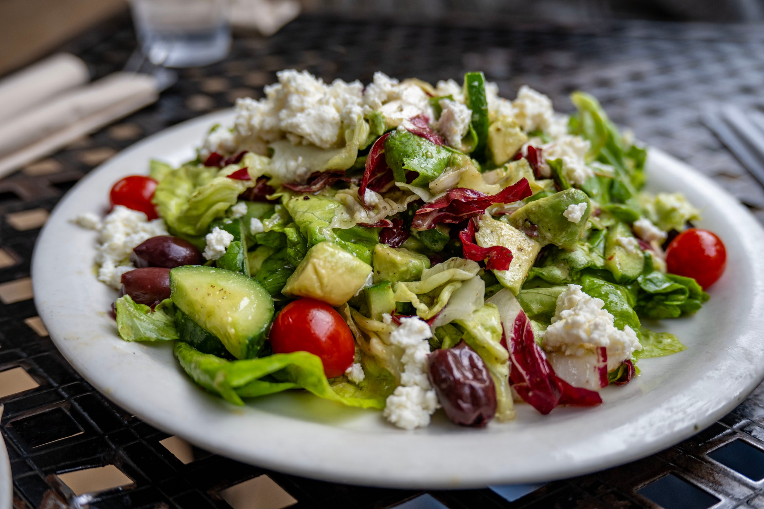 A classic Greek salad with lettuce, cucumber, tomato, feta cheese, and kalamata olive